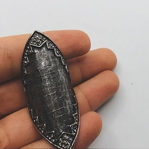 Rhombus silver colored ring with Jews on the side.